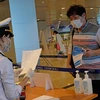Lực lượng chức năng kiểm tra khai báo y tế của những hành khách đáp chuyến bay từ Hàn Quốc đến sân bay Cam Ranh trong chiều 25/2. (Ảnh: Nguyễn Dũng/TTXVN)