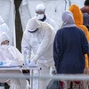 Nhân viên Hội Chữ thập đỏ Italy trong trang phục bảo hộ kiểm tra sức khỏe người di cư nhằm ngăn chặn sự lây lan của dịch COVID-19 tại khu vực cảng Messina, thành phố Sicily ngày 27/2/2020. (Nguồn: AFP/TTXVN)