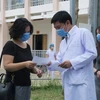 Bác sỹ Trần Chánh Xuân, Phó Giám đốc Bệnh viện dã chiến Củ Chi, trao giấy ra viện cho bệnh nhân số 75. (Ảnh: Đinh Hằng/TTXVN) 