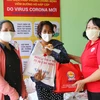 Hội Chữ thập đỏ Quận 3, Thành phố Hồ Chí Minh trao quà cho người bán vé số dạo bị ảnh hưởng dịch bệnh COVID-19. (Ảnh: Thanh Vũ/TTXVN)