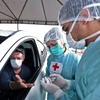 Nhân viên y tế xét nghiệm nhanh COVID-19 cho người dân tại một bãi đỗ xe ở Brasilia, Brazil, ngày 21/4/2020. (Nguồn: AFP/TTXVN)