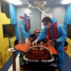 Nhân viên y tế trên tàu cứu nạn chuyên dụng SAR 413 tiến hành sơ cứu ban đầu cho thuyền viên Hồ Minh Tuấn khi lên tàu SAR 413. (Nguồn: TTXVN phát)
