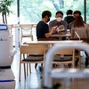 Khách hàng chờ đợi tại quán càphê ở Daejeon khi robot nhận đơn hàng, pha càphê và mang đồ uống đến cho khách hàng. (Nguồn: Reuters)