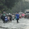 Nhiều tuyến đường ở Quận 2 ngập sâu khiến nhiều người dân khó di chuyển. (Ảnh: Hồng Giang/TTXVN)