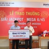 Anh Nguyễn Quốc Thịnh trao quà sau khi nhận giải Jackpot. (Ảnh: Vietlott)