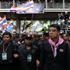  Cảnh sát gác bên ngoài trụ sở chính trong khi người biểu tình chống chính phủ tuần hành tại Bangkok ngày 26/2. (Nguồn: AFP/TTXVN)