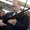 Tổng thống Nga Vladimir Putin kiểm tra một khẩu súng trường trong chuyến thăm một cơ sở sản xuất vũ khí tại Tula. (Nguồn: Reuters)