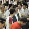 Nhân viên giải thích cho hành khách về việc tuyến đường sắt tạm ngừng hoạt động. (Nguồn: Kyodo) 