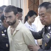 Cảnh sát áp giải nghi can Adem Karadag tới trụ sở Cục cảnh sát thành phố tại Bangkok. (Nguồn: THX/TTXVN)