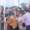 Người hâm mộ "phá rào" của lực lượng an ninh để tràn vào mua vé. (Ảnh: Minh Chiến/Vietnam+)