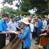 Bí thư Đoàn Thanh niên TTXVN Trần Tiến Duẩn trao quà cho nhân dân vùng lũ xã Hòa Hải. (Ảnh: TTXVN)