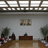 Nhà truyền giáo Hàn Quốc Kim Jeong-wook ngồi nói dưới bức ảnh của các nhà lãnh đạo Triều Tiên Kim Il-sung và Kim Jong-il. (Ảnh: AP)