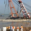 Hệ thống cần trục được triển khai để trục vớt tàu chìm (giữa) trên sông Dương Tử ngày 5/6. (Nguồn: AFP/TTXVN)