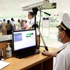 Kiểm tra nhiệt độ hành khách bằng máy đo thân nhiệt tia hồng ngoại tại sân bay Nội Bài. (Ảnh: Dương Ngọc/TTXVN)