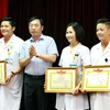 Ông Nguyễn Khắc Hiền, Giám đốc Sở Y tế Hà Nội trao tặng Giấy khen cho Ban lãnh đạo Bệnh viện Phụ sản Hà Nội. (Ảnh: Dương Ngọc/TTXVN)