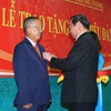 Ông Lê Hồng Anh, Ủy viên Bộ Chính trị, Thường trực Ban Bí thư gắn Huy hiệu 50 năm tuổi Đảng cho ông Trương Vĩnh Trọng. (Ảnh: Doãn Tấn/TTXVN)