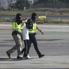 Cảnh sát Tây Ban Nha áp giải đối tượng vừa bị bắt giữ với cáo buộc tuyên truyền và tuyển mộ thành viên cho tổ chức IS tại sân bay ở Melilla ngày 22/7. (Nguồn: AFP/TTXVN)