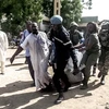 Nhân viên an ninh chuyển thi thể nạn nhân vụ đánh bom kép tại Maroua, bắc Cameroon ngày 22/7. (Nguồn: AFP/TTXVN)