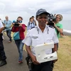 Cảnh sát Pháp với tấm nhựa vừa phát hiện trên đảo Reunion ngày 4/8. (Nguồn: AFP/TTXVN)