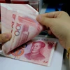 Kiểm tiền giấy mệnh giá 100NDT tại ngân hàng ở Liên vận cảng, tỉnh Giang Tô, Trung Quốc. (Nguồn: AFP/TTXVN)
