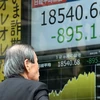 Nhà đầu tư theo dõi bảng điện tử chỉ số chứng khoán tại sàn giao dịch ở Tokyo, Nhật Bản ngày 24/8. (Nguồn: AFP/TTXVN)