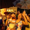 Người dân đứng tại Quảng trường Cánh mạng Tháng Tám xem bắn pháo hoa khu vực Hồ Hoàn Kiếm (Hà Nội). (Ảnh: Quý Trung/TTXVN)