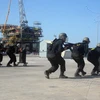 Diễn tập tình huống lực lượng chống khủng bố triển khai đội hình áp sát khu vực giam giữ con tin. (Ảnh: Đoàn Mạnh Dương/TTXVN)