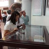 Các đại biểu tham quan trưng bày tư liệu di vật của gia tộc Nguyễn Du tại Bảo tàng tỉnh Bắc Ninh. (Ảnh: Thái Hùng/TTXVN)