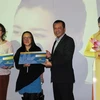 Ông Ngô Trí Hưng, Trưởng Chi nhánh Vietnam Ailines tại Đức, trao vé máy bay cho khách hàng may mắn trúng thưởng. (Ảnh: Mạnh Hùng/Vietnam+)