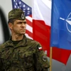 Một binh sỹ Ba Lan đứng bên lá cờ Mỹ, Ba Lan và NATO. (Nguồn: Reuters)