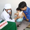 Bác sỹ Trạm y tế xã Triệu Trạch (Quảng Trị) khám phân loại trẻ trước khi tiêm vắcxin Quinvaxem. (Ảnh: Hồ Cầu/TTXVN)