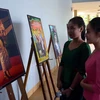 Lưu học sinh Lào tham quan Triển lãm ảnh “Sắc hoa Chămpa” trong chương trình “Giao lưu hữu nghị Việt- Lào tại Quảng Nam. (Ảnh: Đỗ Trưởng/TTXVN)
