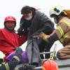 Nhân viên cứu hộ đưa một phụ nữ bị mắc kẹt ra khỏi đống đổ sau trận động đất. (Nguồn: THX/TTXVN)