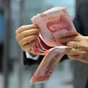 Nhân viên ngân hàng kiểm tiền 100 nhân dân tệ tại một ngân hàng ở Hàng Châu, tỉnh Chiết Giang, miền đông Trung Quốc ngày 1/12. (Nguồn: AFP/TTXVN)