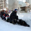 Khách tham quan đi trên một mô hình đầu máy hơi nước tại Lễ hội Tuyết. (Nguồn: AFP/TTXVN)