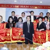 Ông Nguyễn Đức Lợi, Ủy viên Trung ương Đảng, Bí thư Đảng ủy, Tổng Giám đốc TTXVN trao tặng Cờ Thi đua cho các đơn vị. (Ảnh: An Đăng/TTXVN)