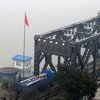 Xe tải của Trung Quốc qua cầu Yalu từ thị trấn cửa khẩu Dandong, hướng tới thị trấn Sinuiju của Triều Tiên ngày 3/3. (Nguoonf: AFP/TTXVN)
