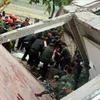 Lực lượng cứu hộ tìm kiếm nạn nhân trong đống đổ nát. (Ảnh: Quốc Đạt/TTXVN)