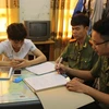 Đối tượng Bùi Đức Hải (áo trắng) bị triệu tập tại cơ quan Công an tỉnh Thái Bình. (Ảnh: Xuân Tiến/TTXVN)