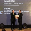 Bộ trưởng Bộ Khoa học và Công nghệ Chu Ngọc Anh (bên trái) trao giải thưởng "Nhà khoa học trẻ có công trình khoa học xuất sắc" cho tiến sỹ Phùng Văn Đồng, Viện Vật Lý, Viện Hàn lâm Khoa học và Công nghệ Việt Nam. (Ảnh: Anh Tuấn/TTXVN)
