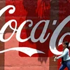 Một phụ nữ bước qua quảng cáo Cocacola trên một bức tường tại Caracas. (Nguồn: AFP)