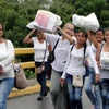 Người dân Venezuela vượt hàng rào chắn do quân đội dựng lên và tràn sang thành phố Cucuta, Colombia để mua lương thực, thực phẩm và thuốc men ngày 5/7. (Nguồn: EPA/TTXVN)