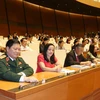 Các đại biểu Quốc hội biểu quyết thông qua Nghị quyết phê chuẩn đề nghị của Chủ tịch nước về danh sách các Phó Chủ tịch và các Ủy viên Hội đồng quốc phòng và an ninh. (Ảnh: Trọng Đức/TTXVN)