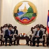 Bộ trưởng Bộ Công Thương Trần Tuấn Anh chào xã giao Thủ tướng Lào Thoongloun Sisoulith. (Ảnh: Phạm Kiên/TTXVN)