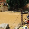 Hàng tiếp tế được vận chuyển bằng cáp treo qua chiếc cầu đã bị sập đến hai thôn Sủng Hoảng 1, Sủng Hoảng 2. (Ảnh: Hương Thu/TTXVN)