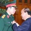 Thủ tướng Nguyễn Xuân Phúc trao tặng Huân chương lao động hạng Nhất cho vận động viên Hoàng Xuân Vinh. (Ảnh: Thống Nhất/TTXVN)