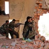 Các tay súng người Kurd chiếm giữ một tòa nhà bị hư hỏng tại Hasaka. (Nguồn: Reuters)