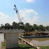Đơn vị thi công đang đúc hoàn thiện trụ cầu Bến Đình, phần giữa sông Vàm Cỏ Đông. (Ảnh: Lê Đức Hoảnh/TTXVN)