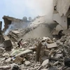 Nhân viên cứu hộ Syria tìm kiếm nạn nhân dưới những đống đổ nát sau vụ không kích tại Aleppo ngày 27/8. (Nguồn: AFP/TTXVN)