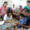 Bác sỹ thăm khám và điều trị cho trẻ bị ngộ độc thực phẩm tại Bệnh viện Nhi Nam Định. (Ảnh: Văn Đạt/TTXVN)